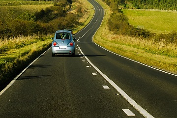 A car driving along an open country road.