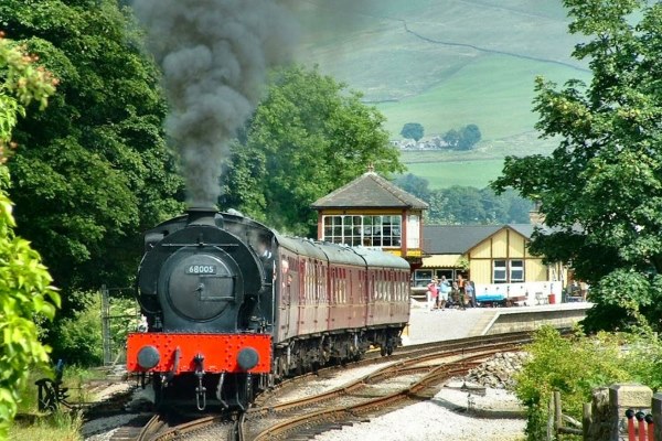 Bolton Abbey Station with a train leaving.