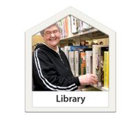 A woman choosing books at a library.