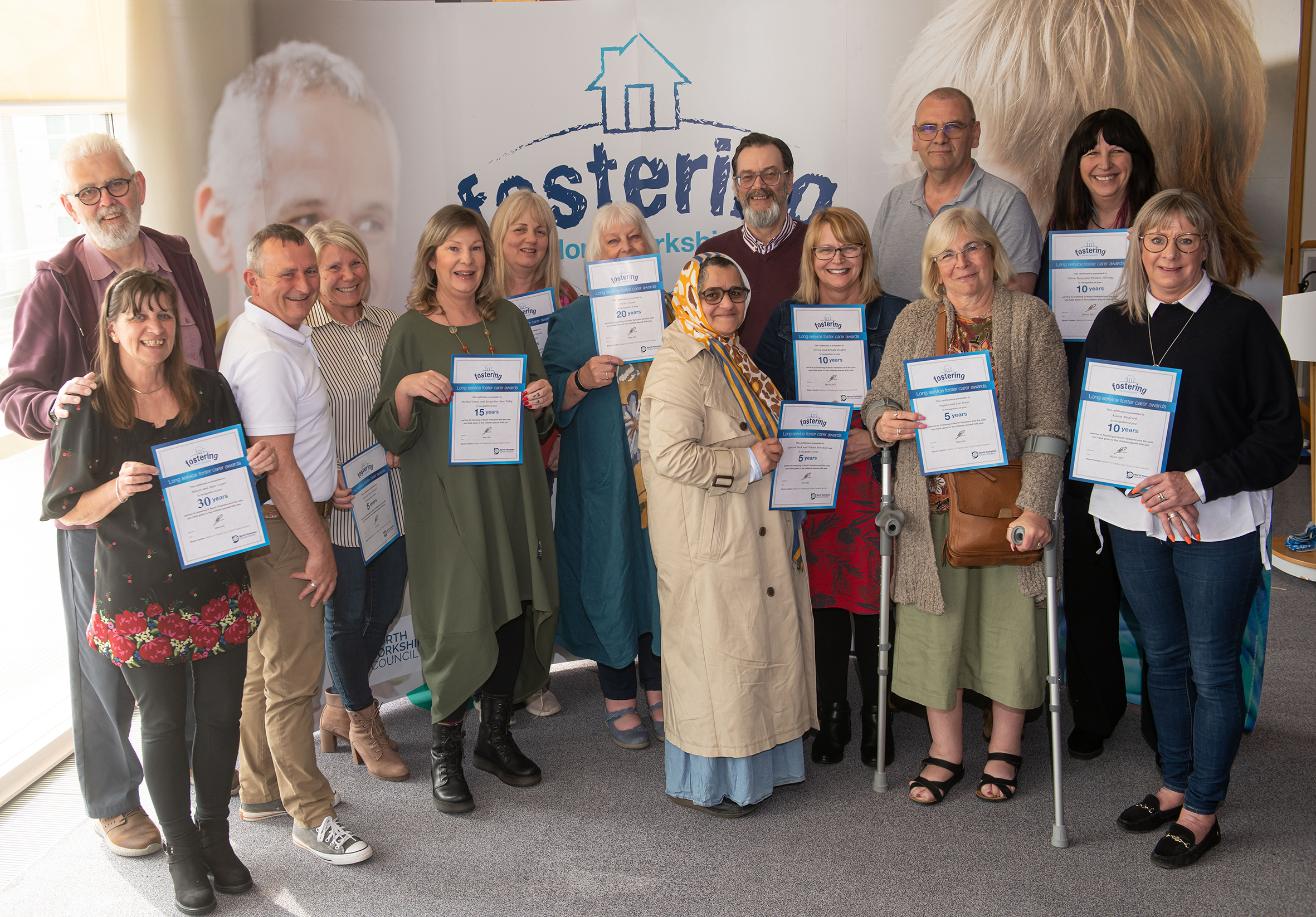 A group of foster carers with certificates