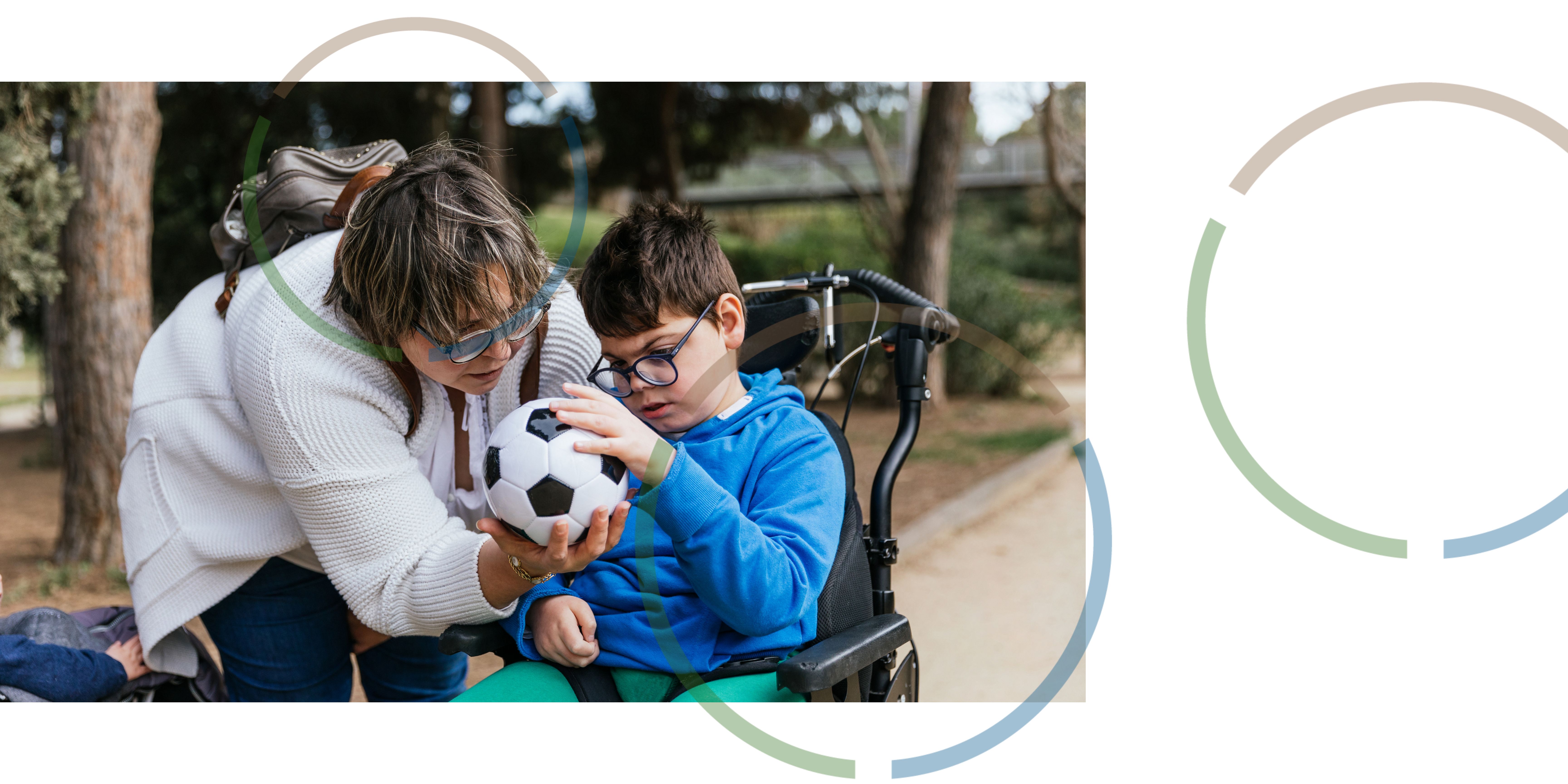 A woman giving a boy a football.