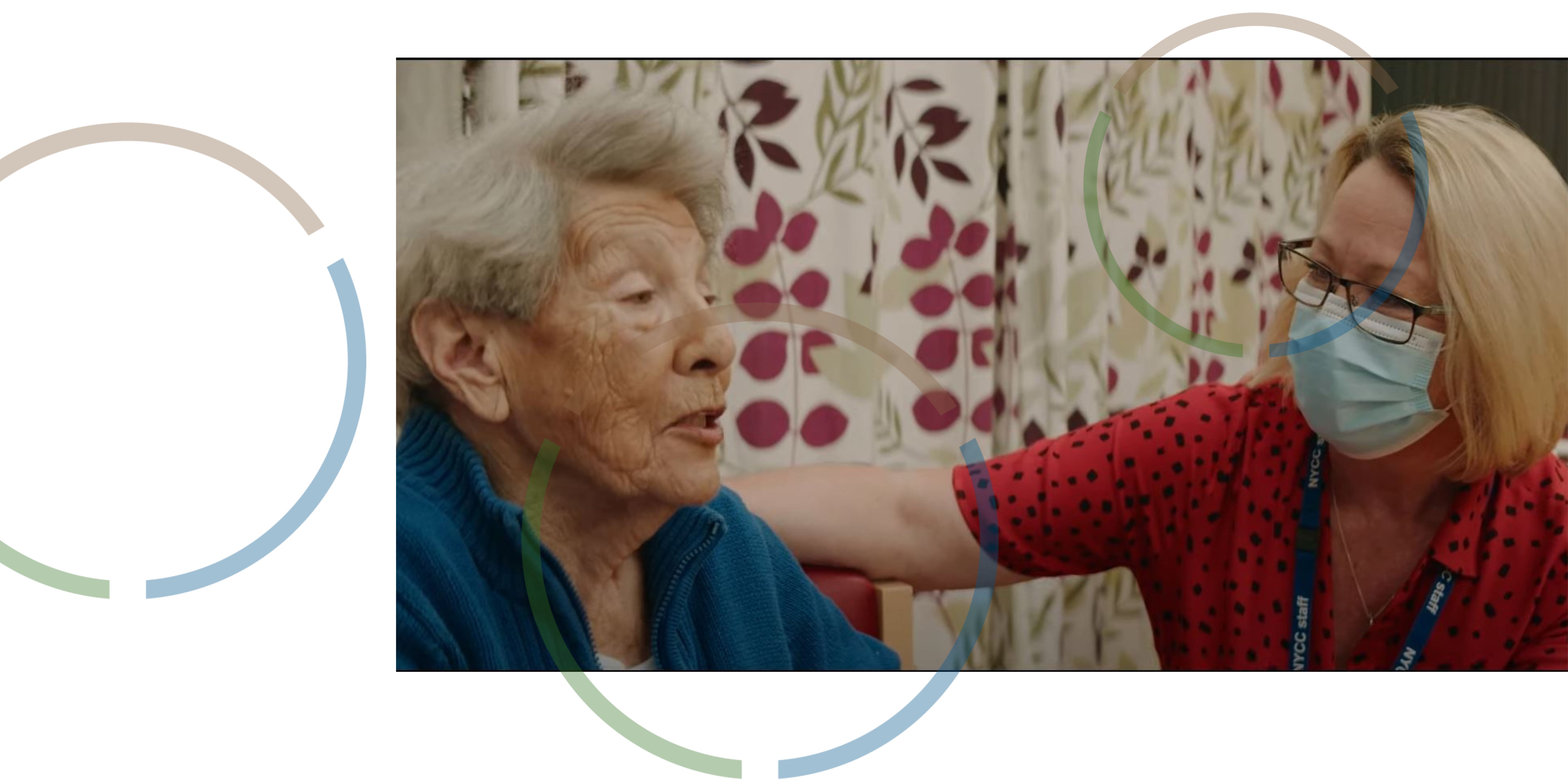 A woman talking to a carer wearing a face mask.