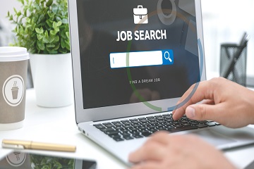 An open laptop showing a job search page on the screen.