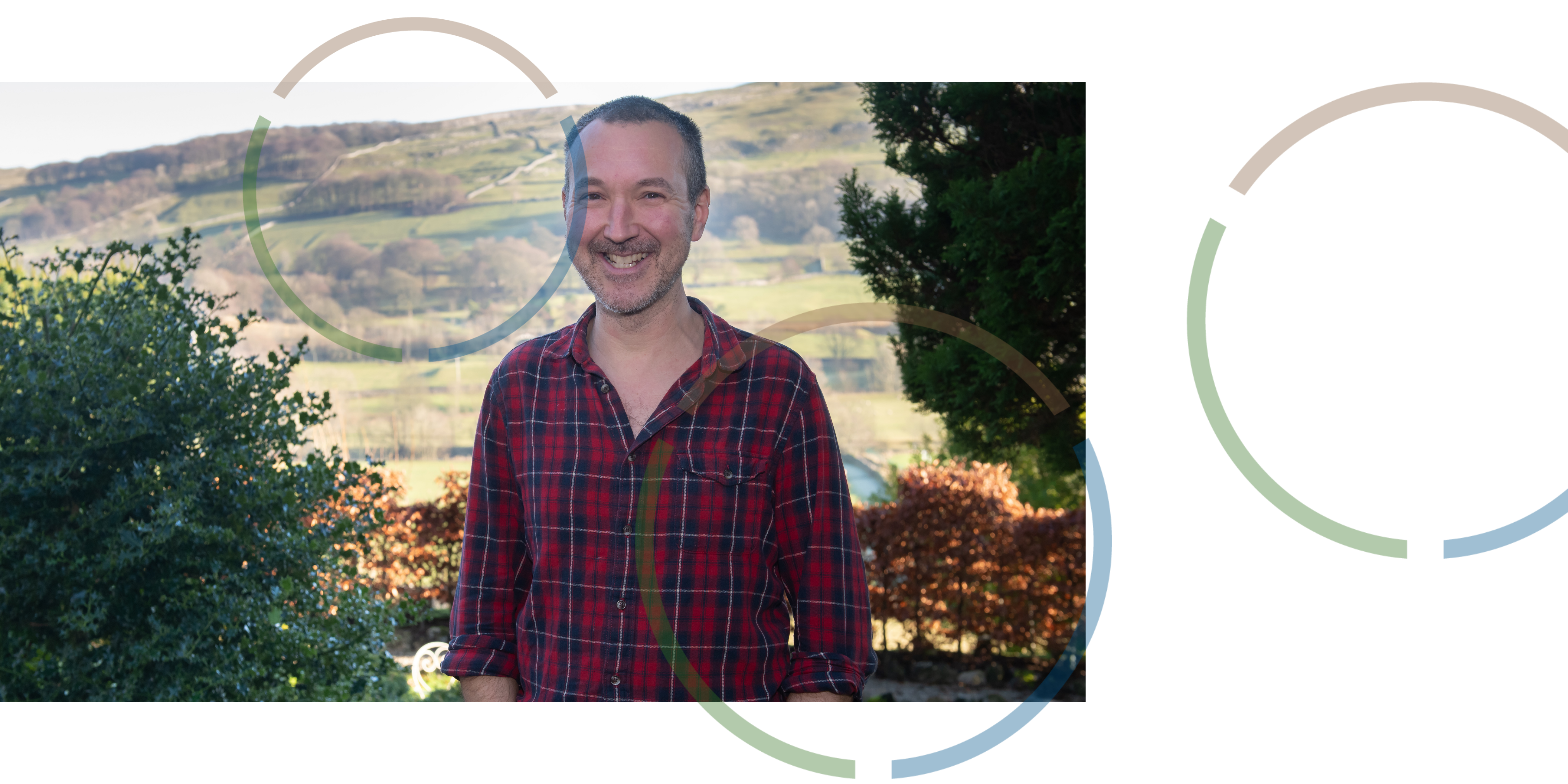 A man smiling in front of a view of North Yorkshire.