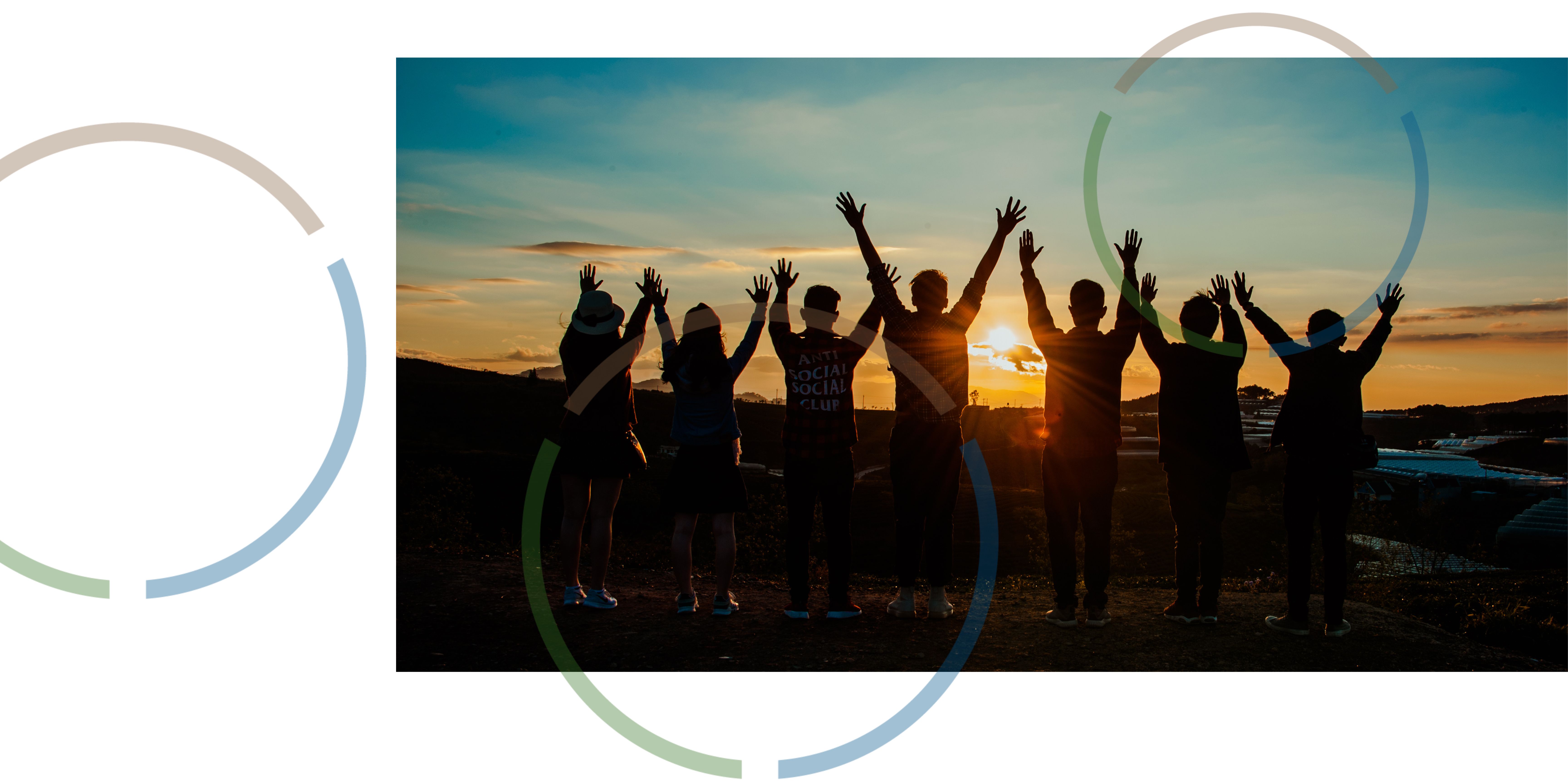 People celebrating in front of a sunset.