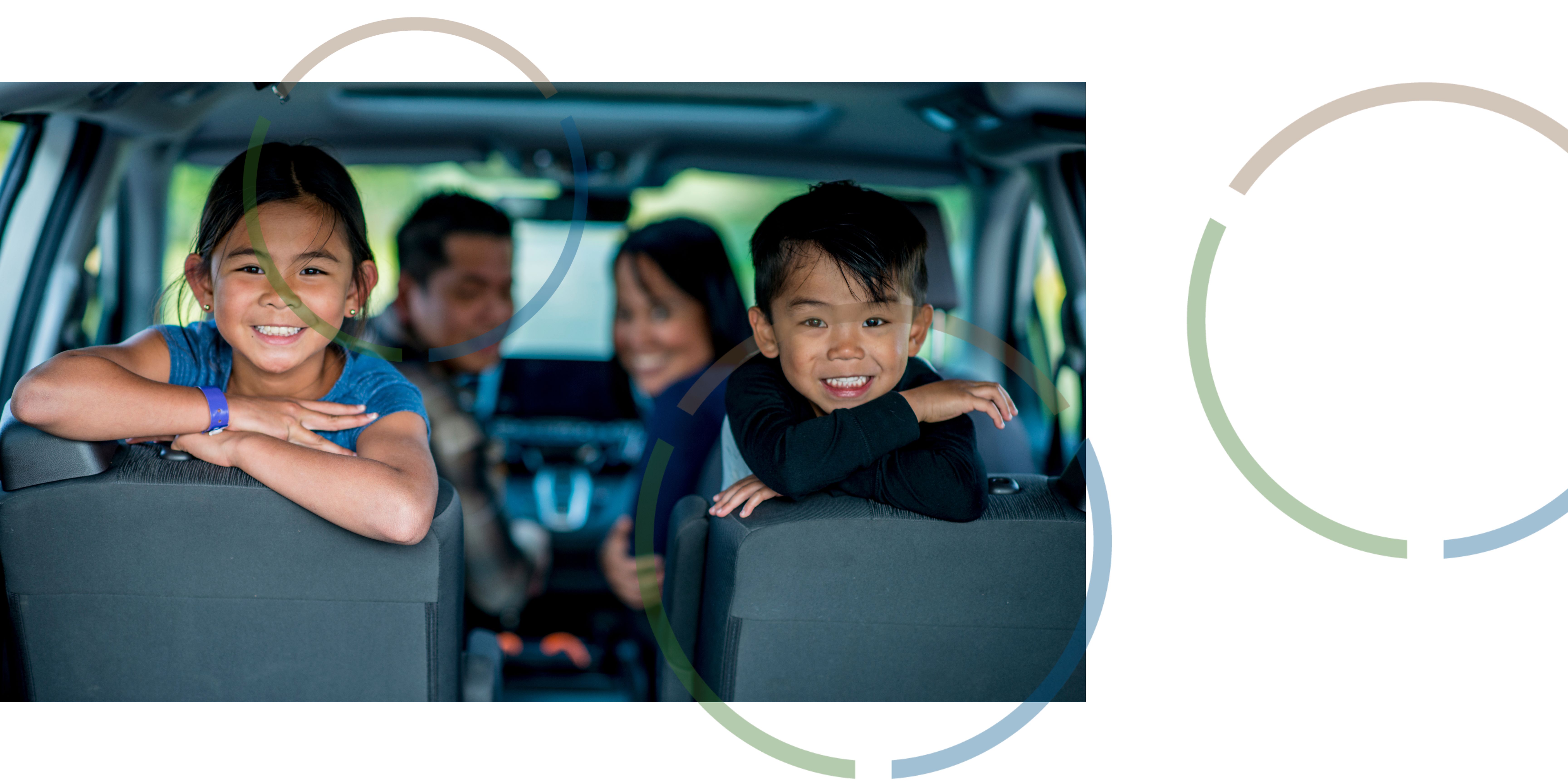 A family smiling in a car.