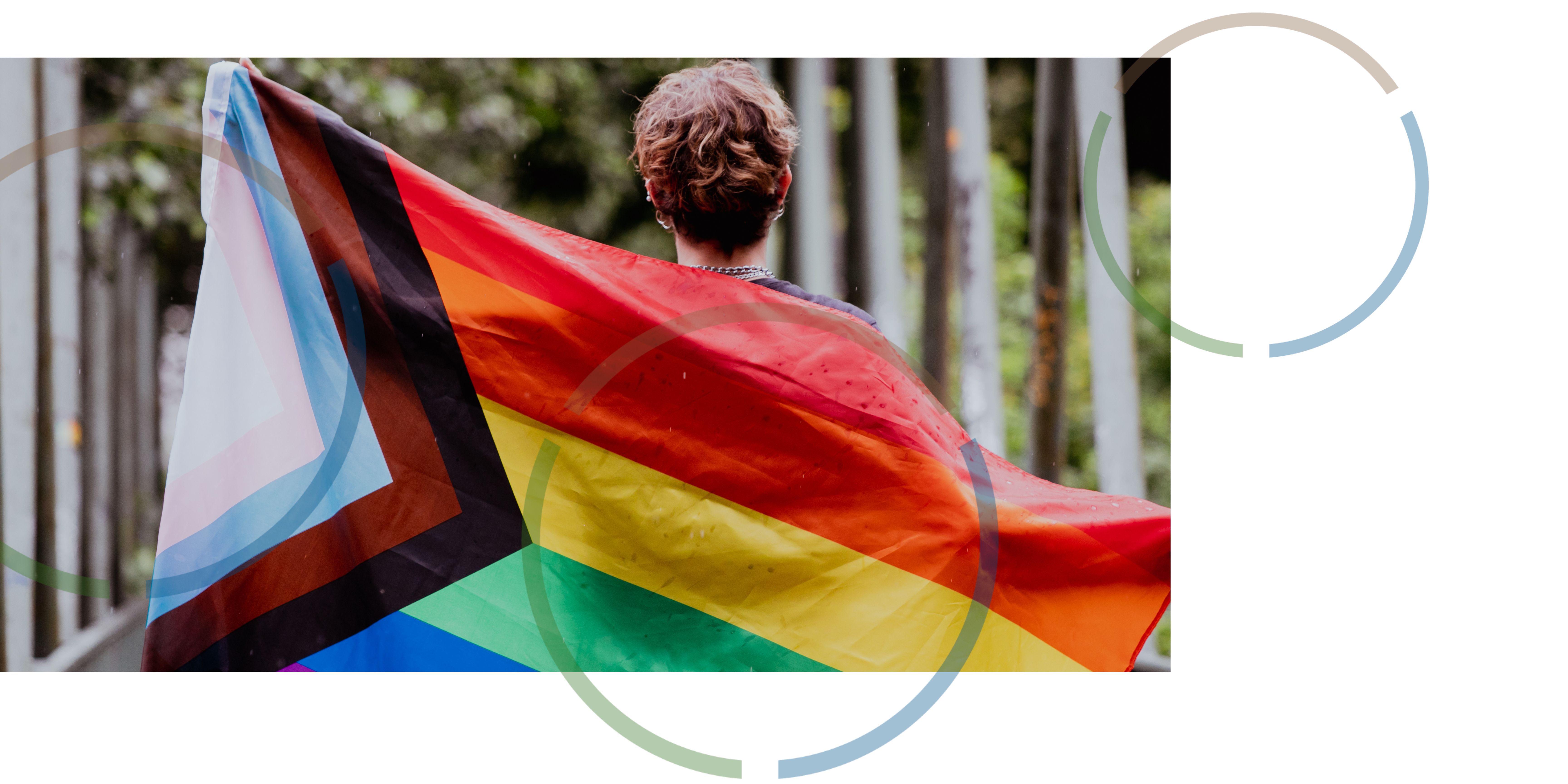 A person holding up a progress pride flag.