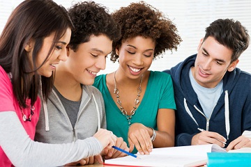 Young people reading a book together.