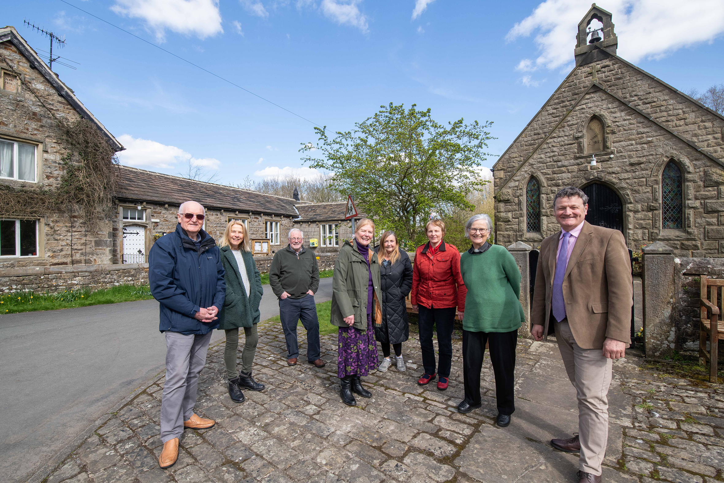 A group of people outside a cottage