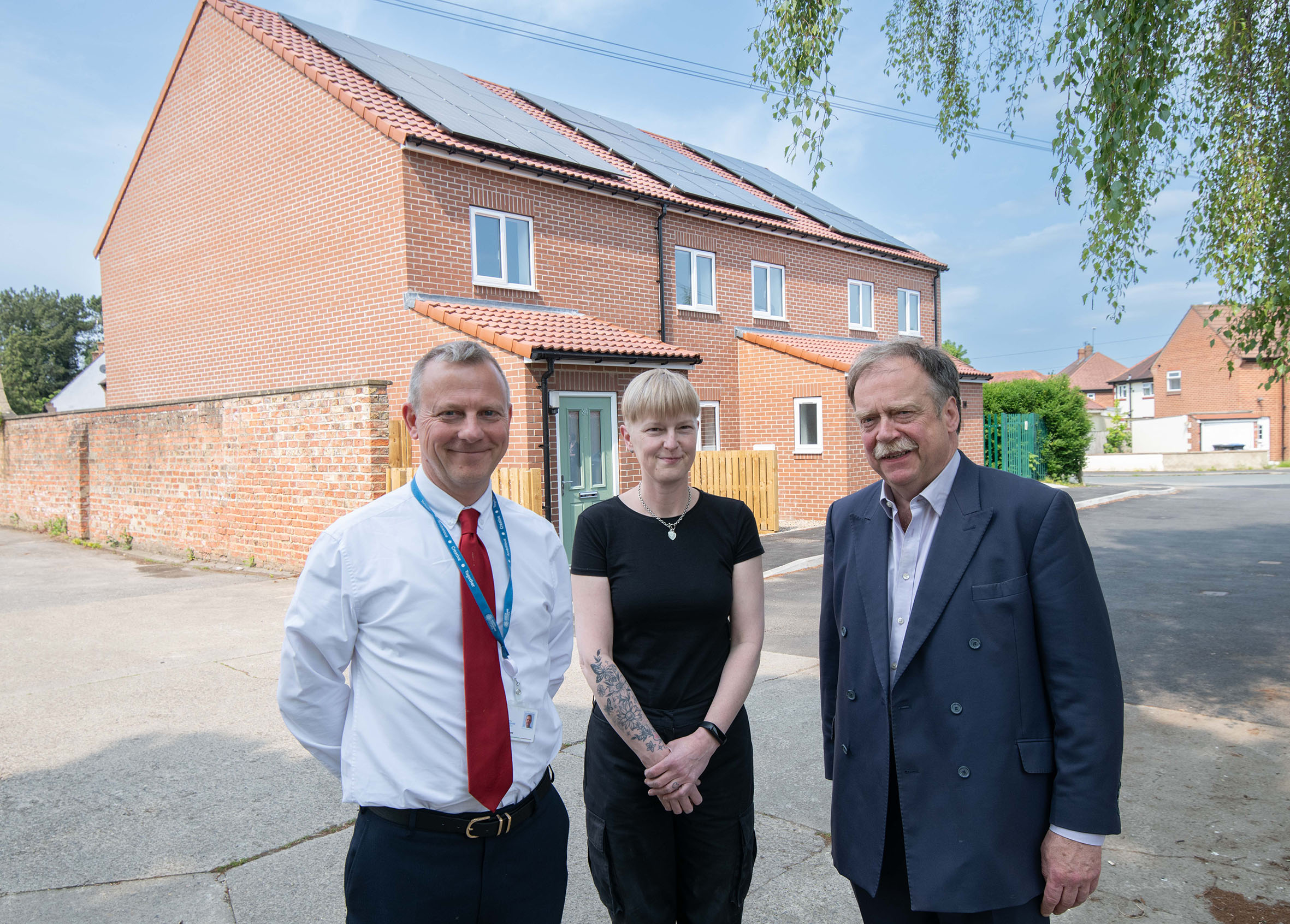 Executive member for housing, Cllr Simon Myers (right), Clare Edwards and North Yorkshire Council’s head of housing, Andrew Rowe, outside the new homes in Ripon. 