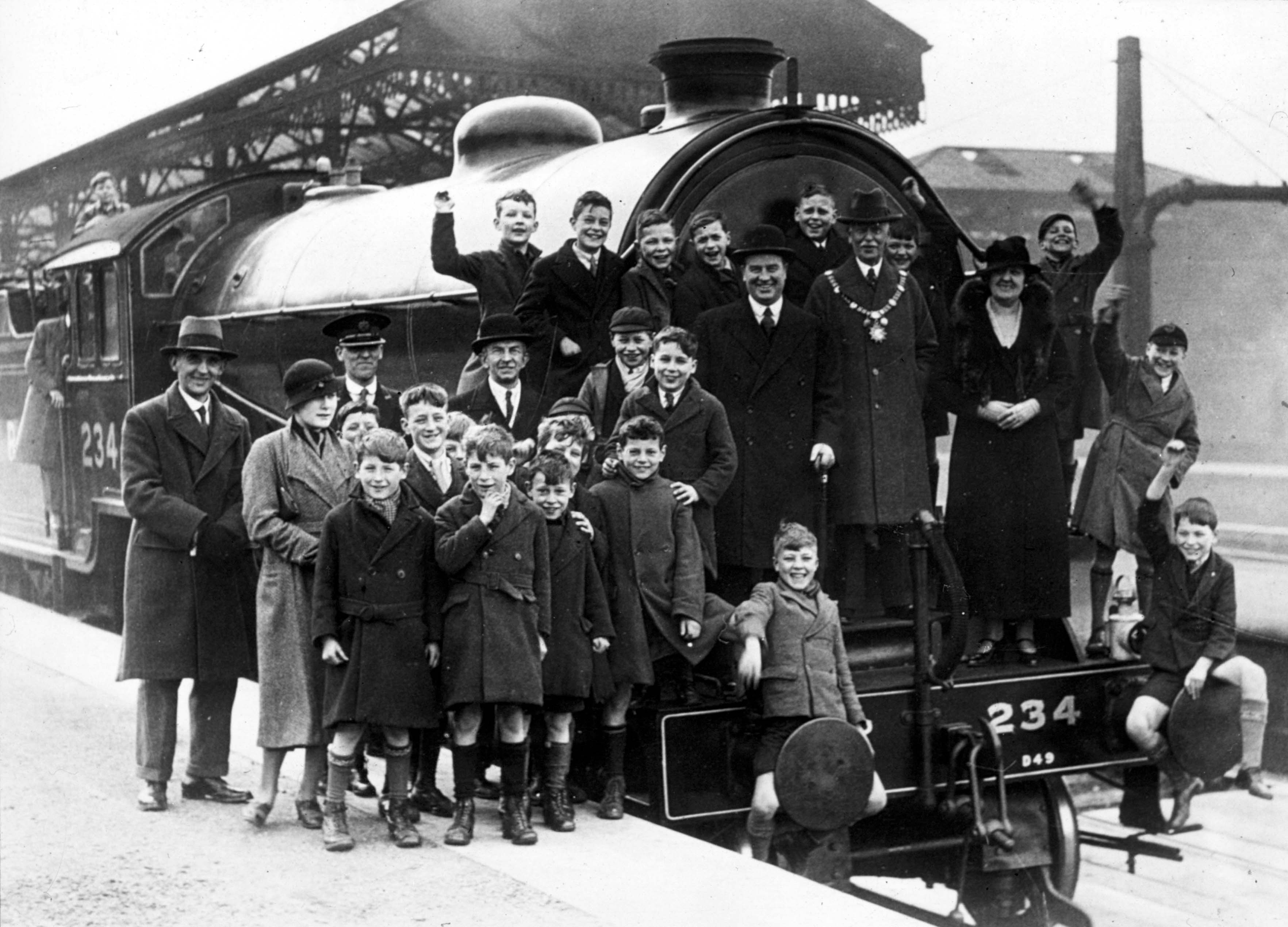 A group of schoolboys pictured with the Mayor and Mayoress Mr and Mrs Hamilton on the front of a steam train in Harrogate Station c1935