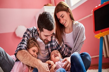 A family playing together on the floor.