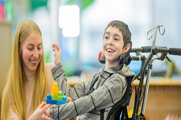 A woman and a boy playing with toys. 