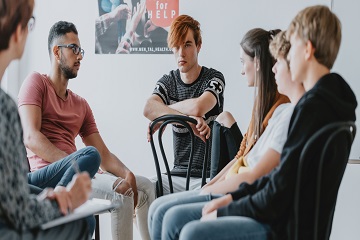 Teenagers sitting in a circle and talking.