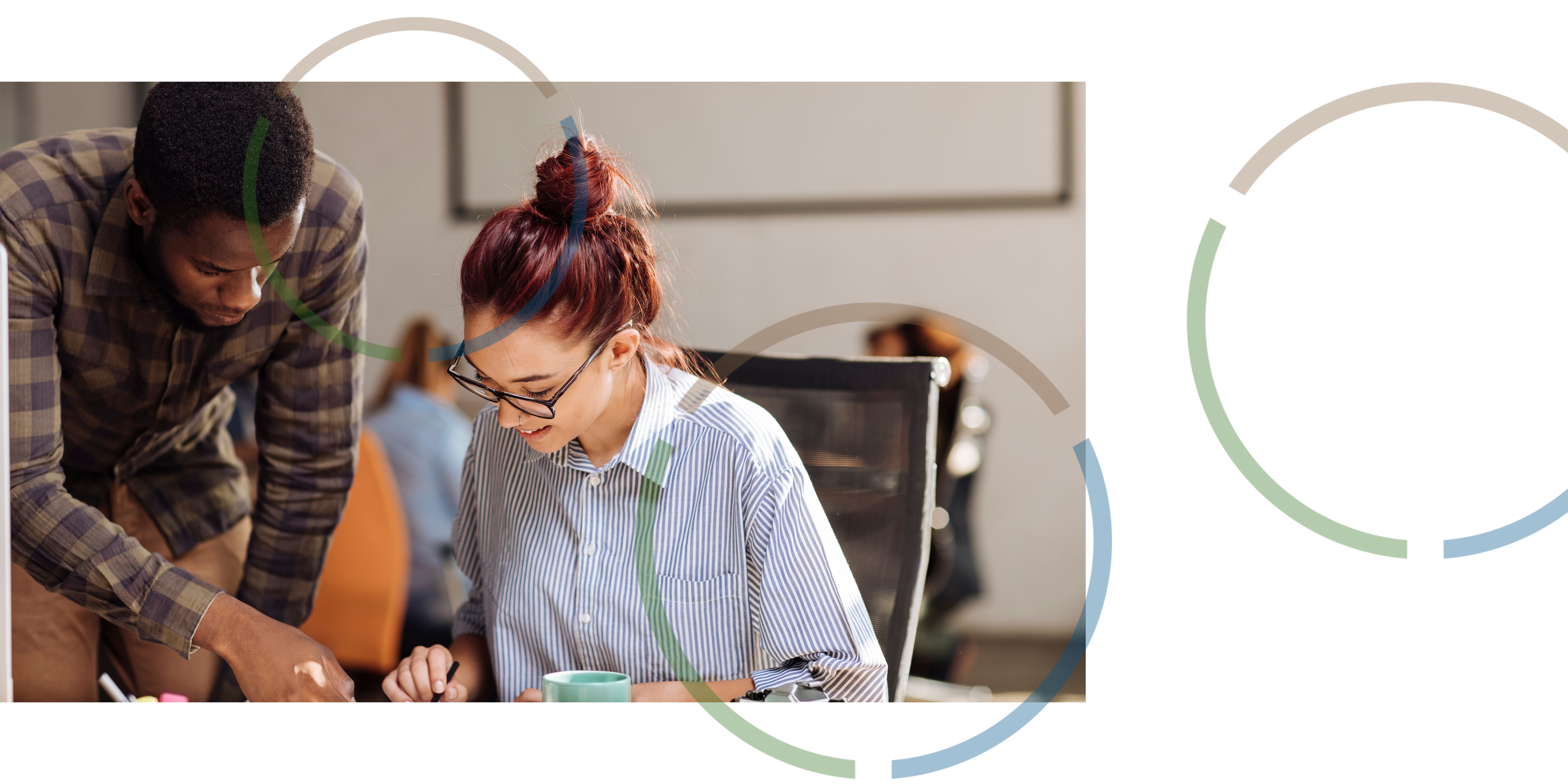 A man and a woman looking at information together in an office.