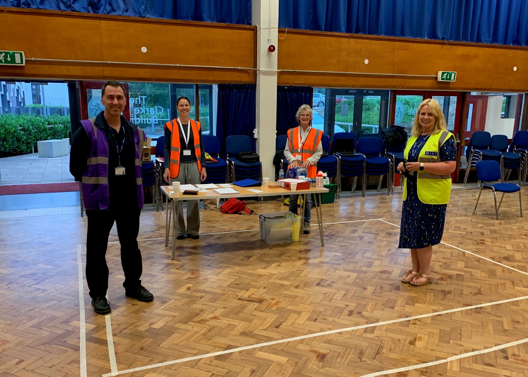 Volunteers in hi-vis jackets welcoming visitors to a rest centre.