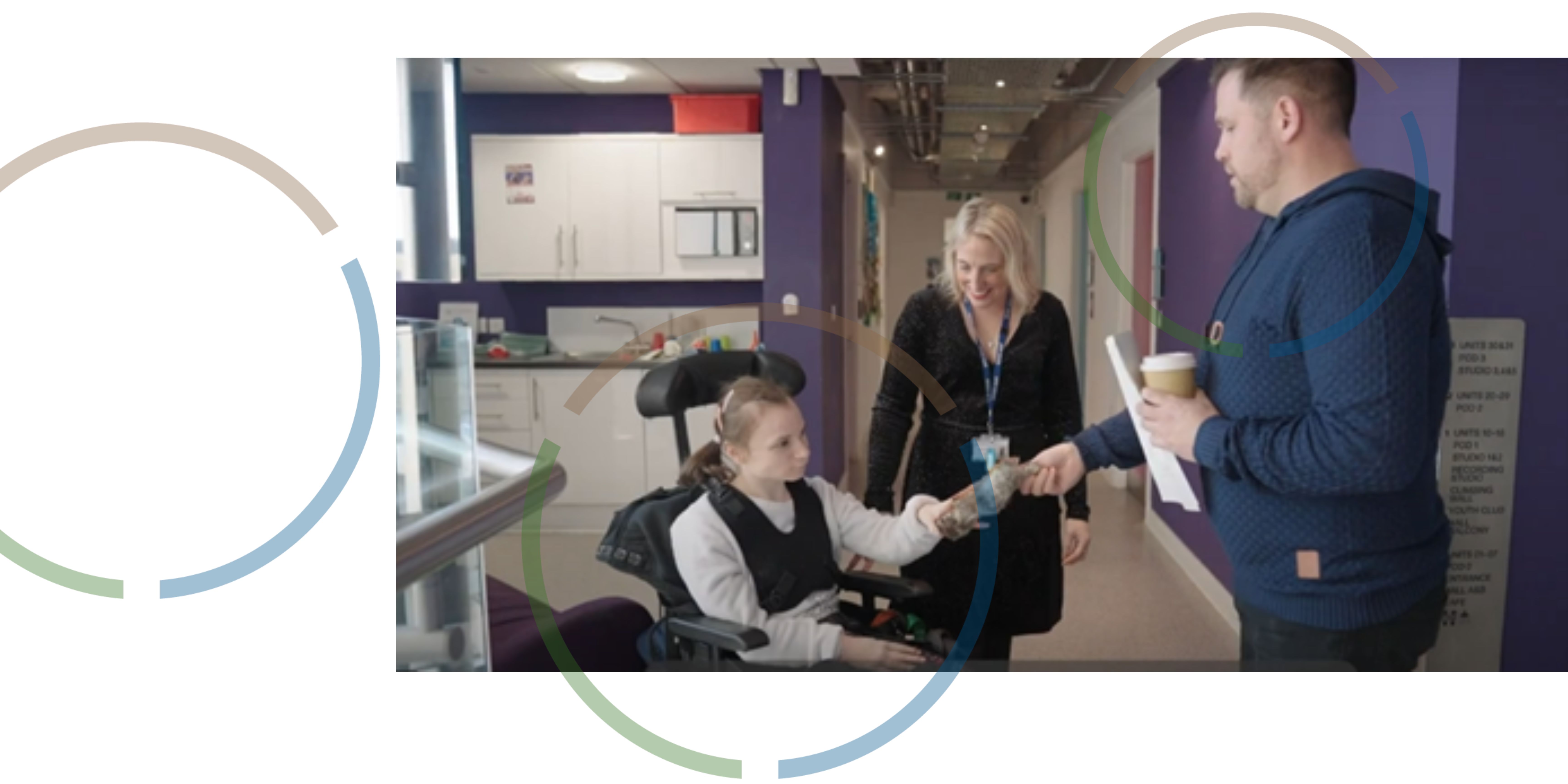 A man and a woman talking to a girl in a wheelchair.