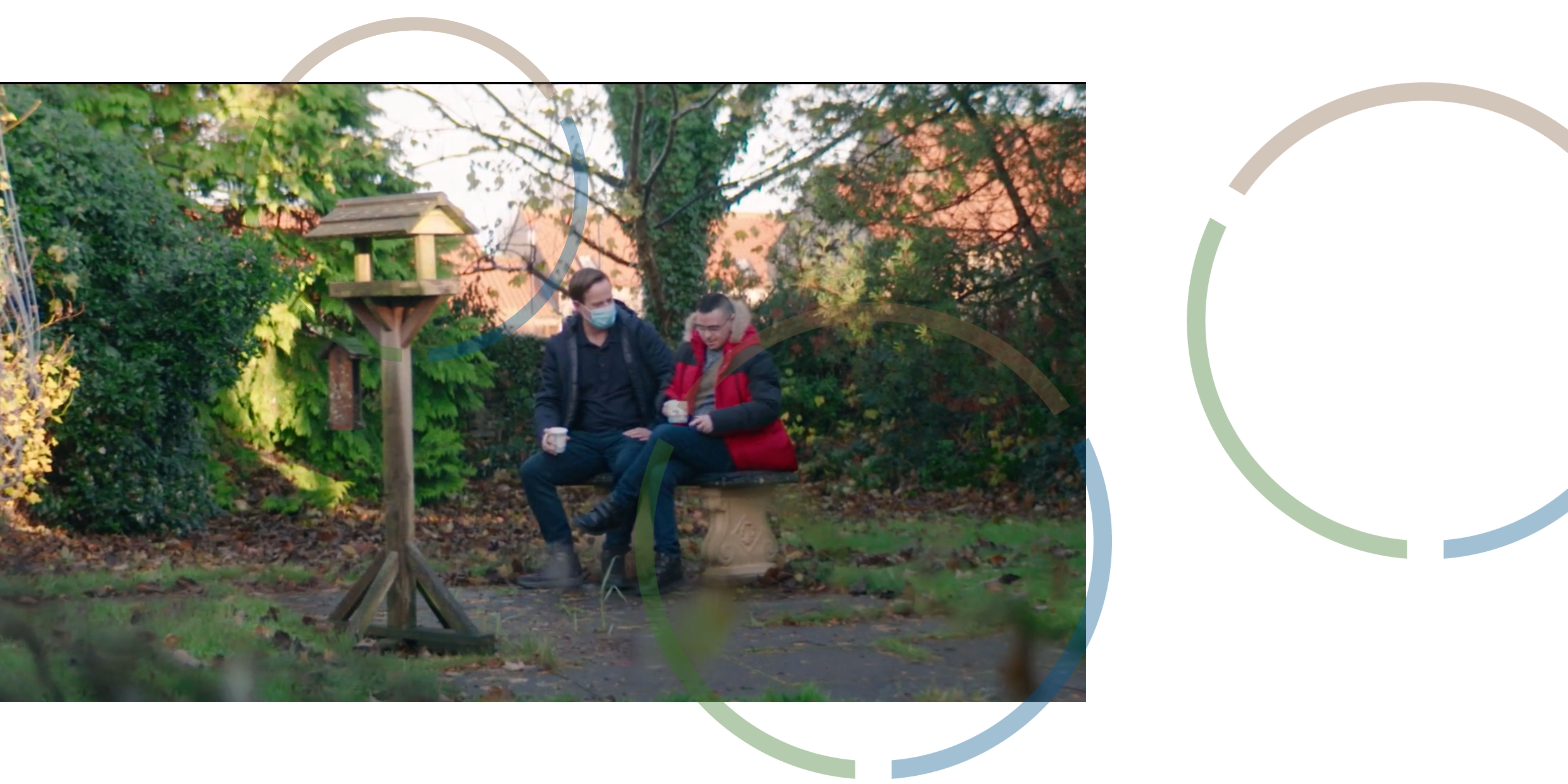 Two men sitting on a bench in a park.