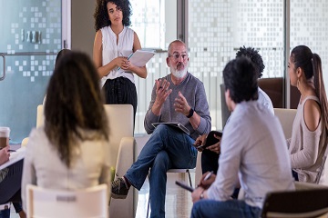 People sitting and standing in a circle and talking.