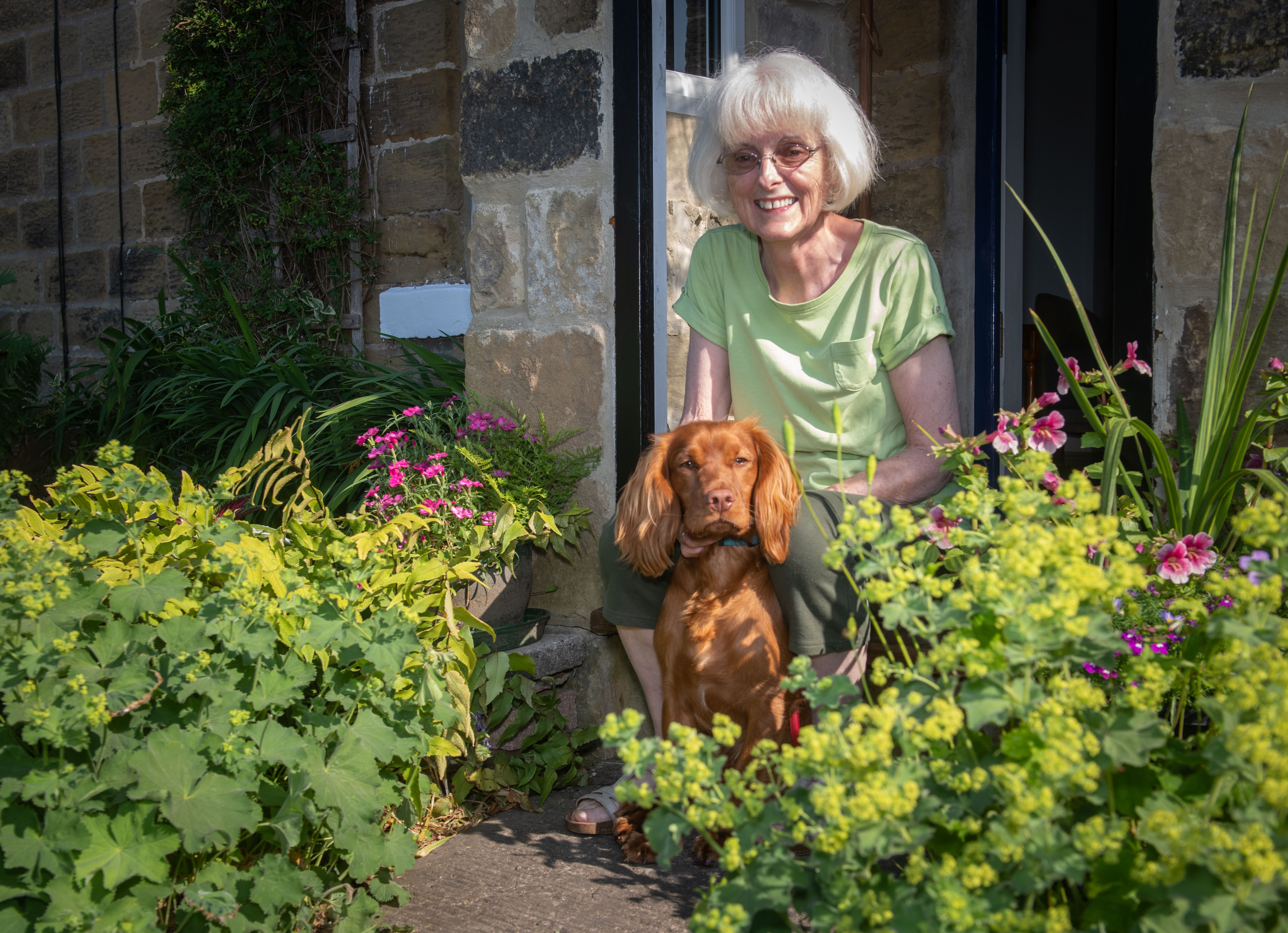 Siobhan Moore sitting outside with a dog. 