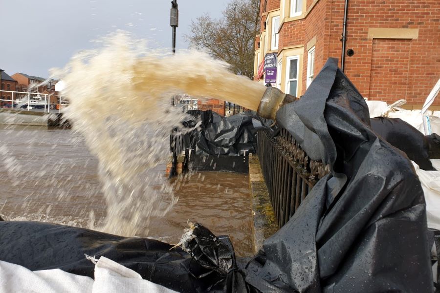 A close-up of a hosepipe spraying a jet of water.