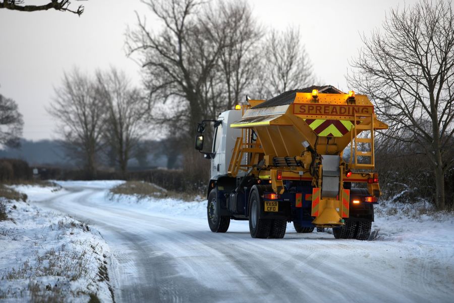 A gritter travelling along a snowy road