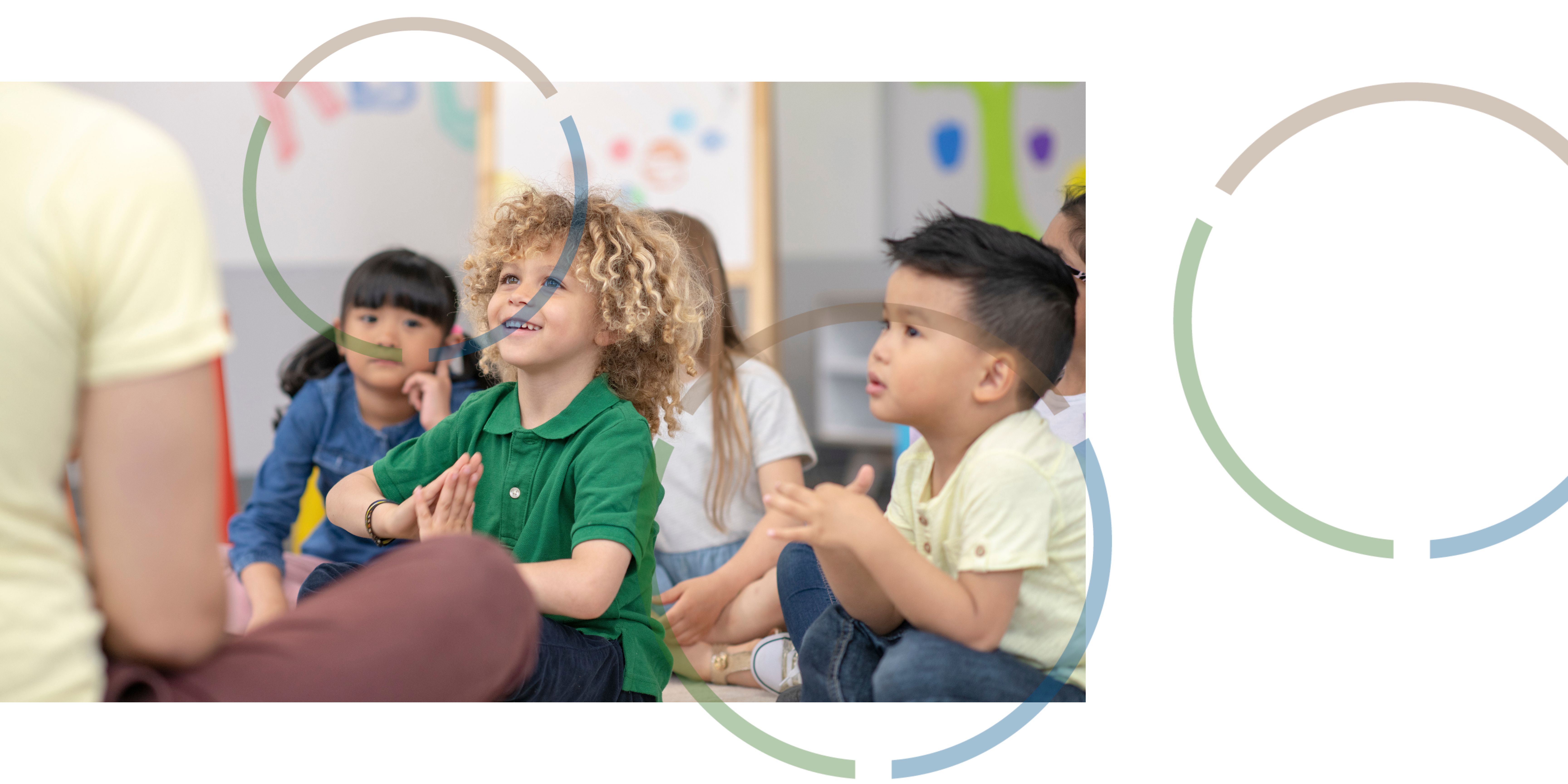 Children sitting on the floor in a classroom. 