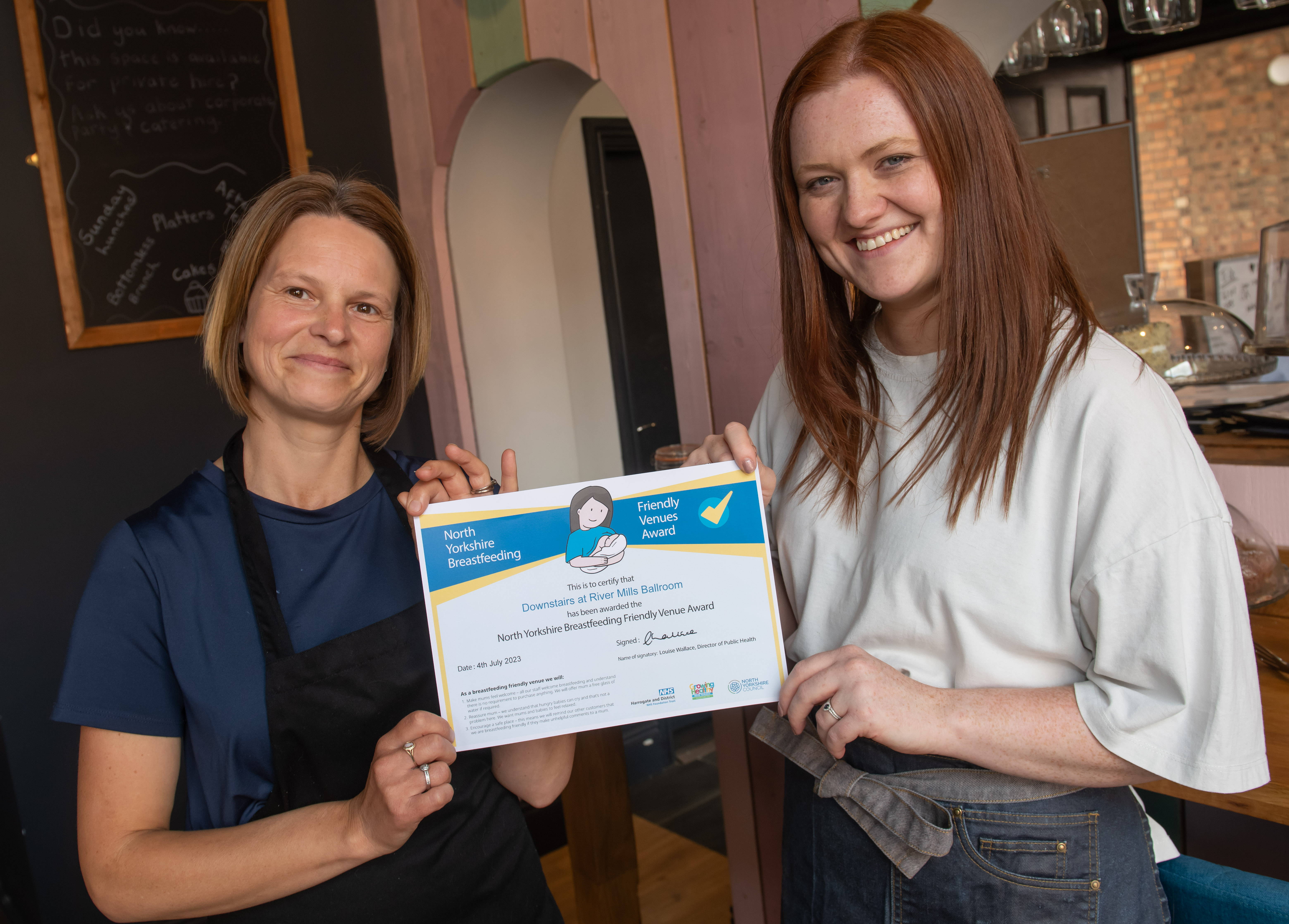 Two ladies with a breastfeeding friendly venue award