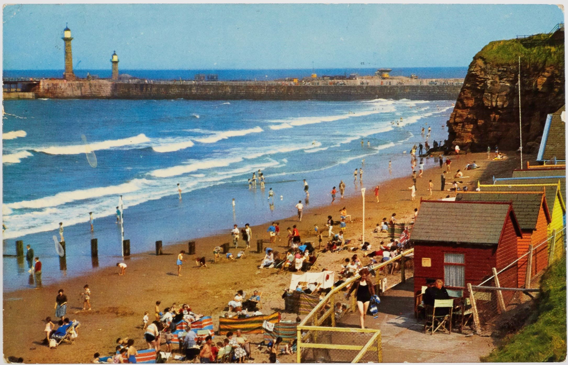 A colour postcard showing the beach at Whitby, circa 1960s to 1970s.