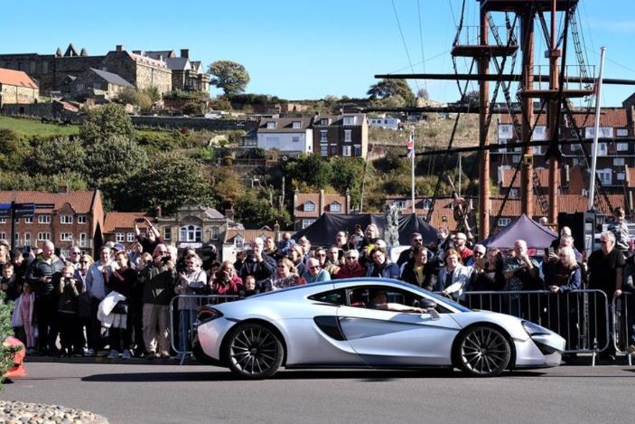 A supercar in Whitby with the Endeavour ship in the background 