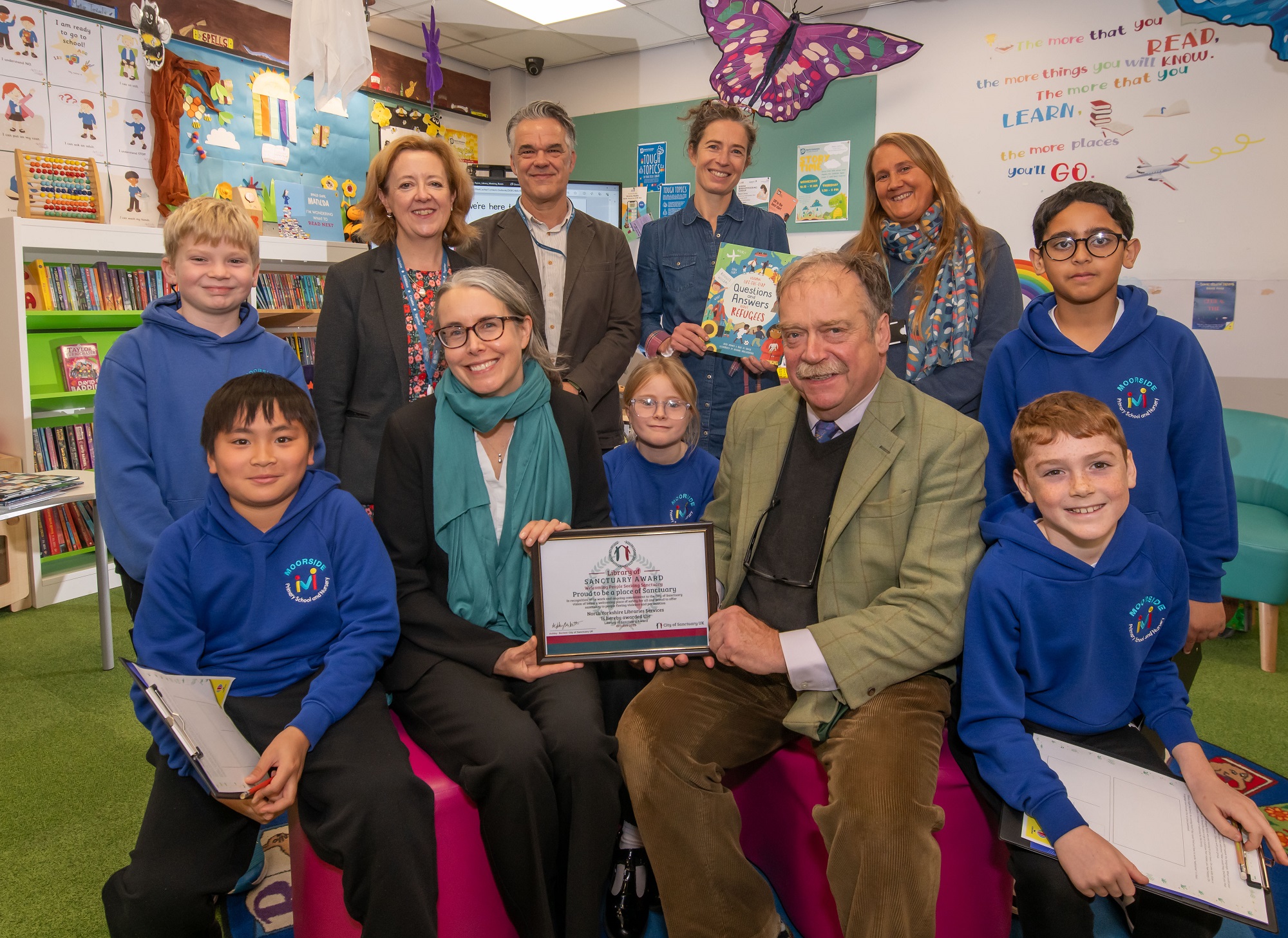 : Author Katie Daynes holding her lift-the-flap book and Cllr Simon Myers with the award (front right) surrounded by pupils from Moorside Primary School and staff at Ripon Library.