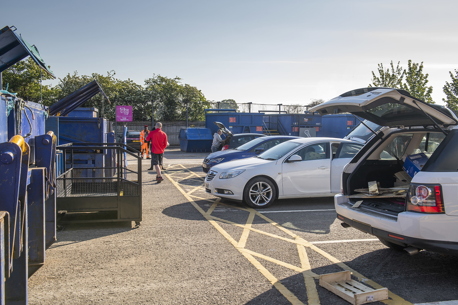 People disposing waste at a household waste recycling centre