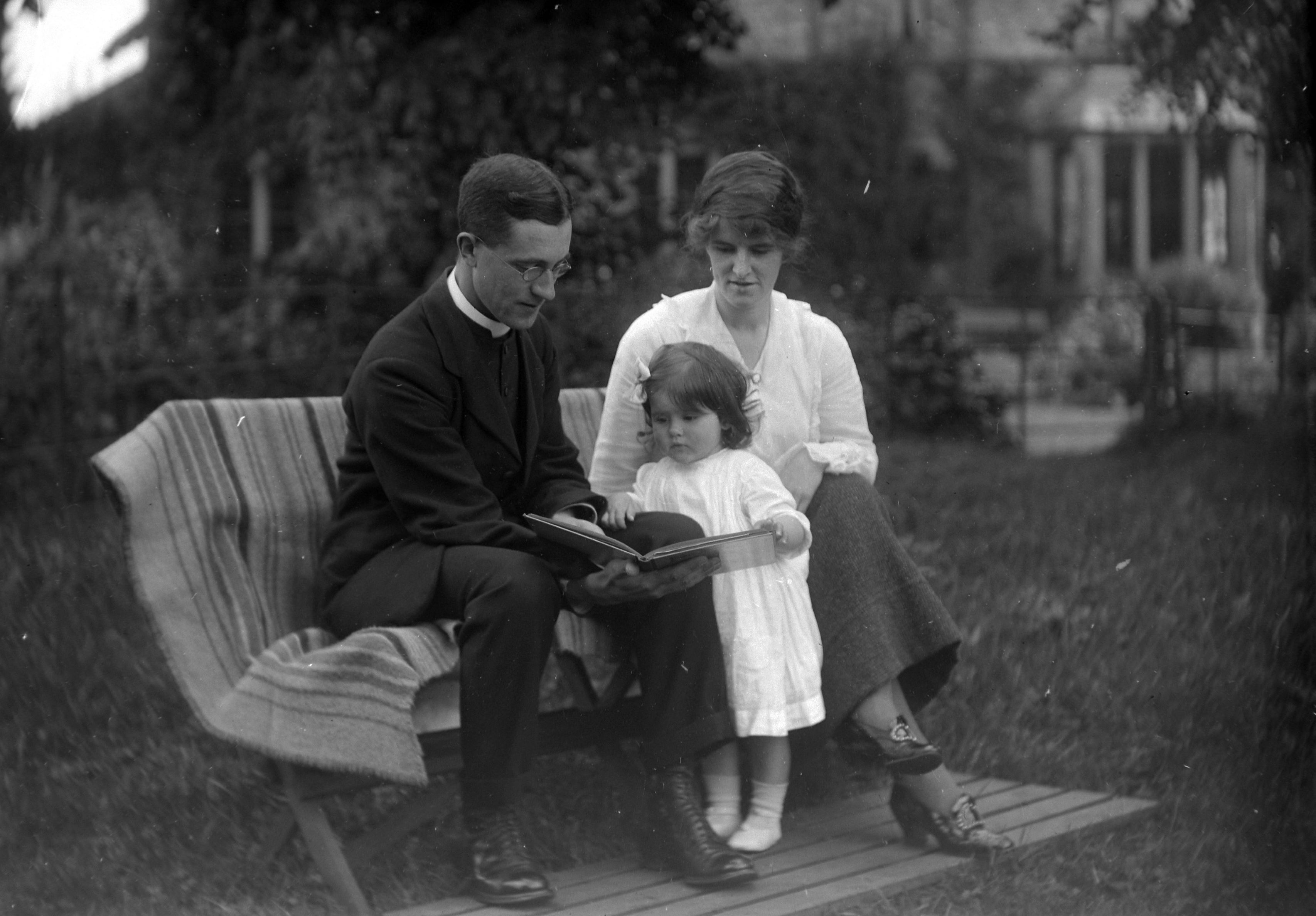 Jim, Eva and a child named as Nancy, reading in a garden at Lower Dunsforth in August 1917. The image is from a collection of photographs by local amateur photographer Louisa Kruckenberg.
