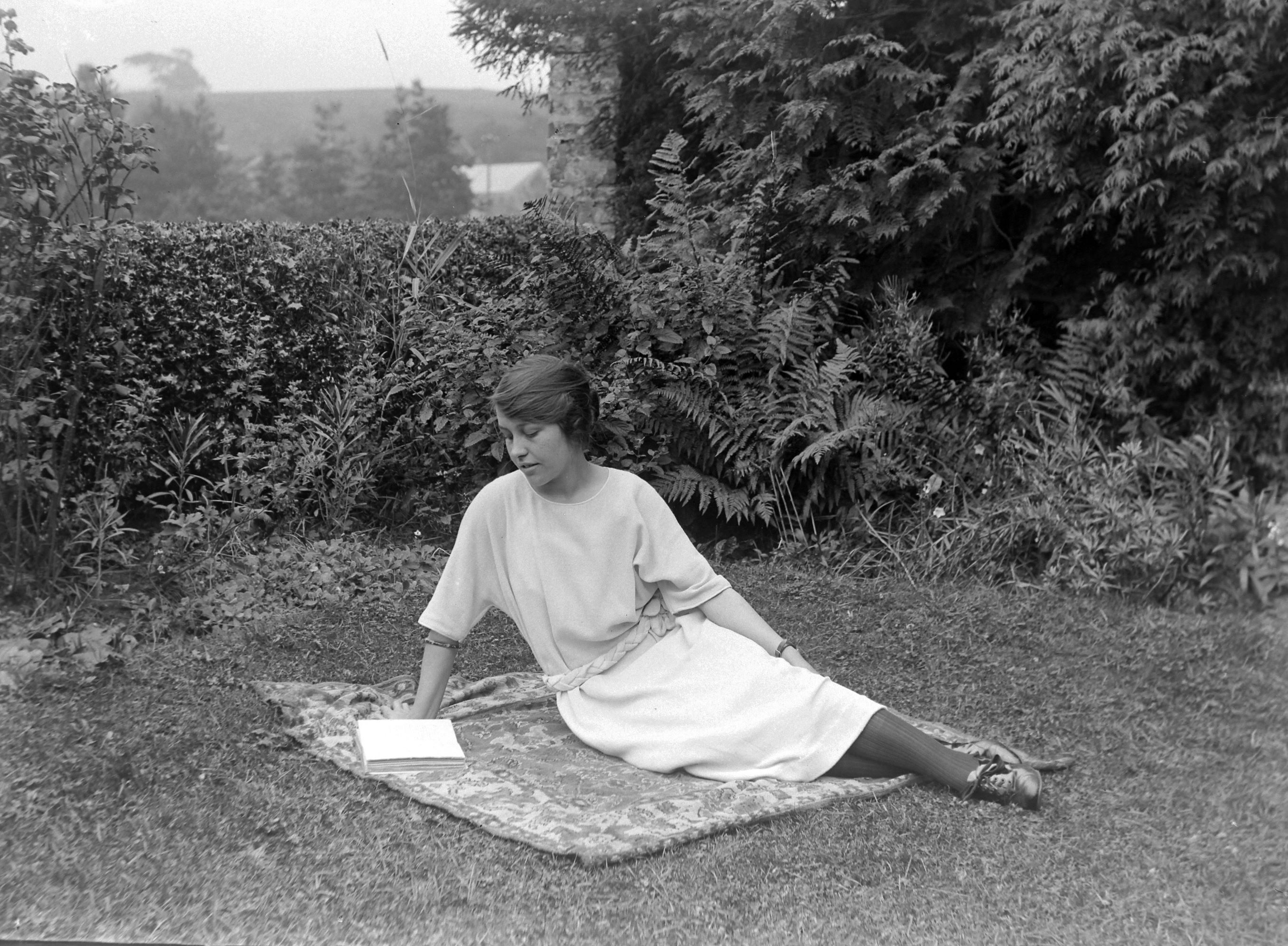 A girl reading in a garden at Lower Dunsforth in August 1923. The image is from a collection of photographs by local amateur photographer Louisa Kruckenberg.
