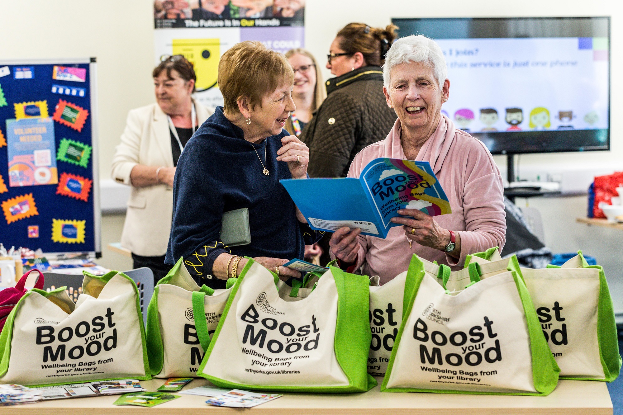 Home library service volunteers, Jennie Leitch (left) and Annabel Garnett, looking through the resources included in the wellbeing bags.