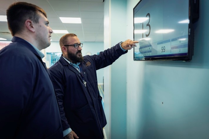 Two businessmen looking at a presentation on a screen.