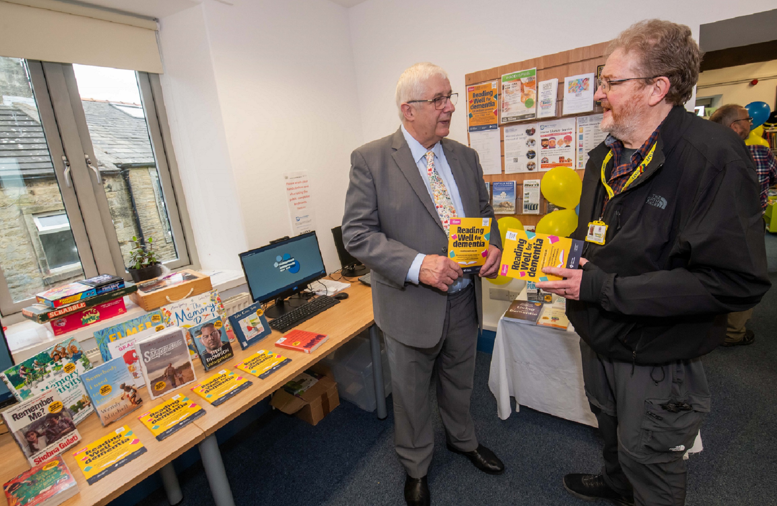 Cllr David Ireton (left) with dementia support advisor at Dementia Forward, Ralph Edwards, alongside the book collection. 