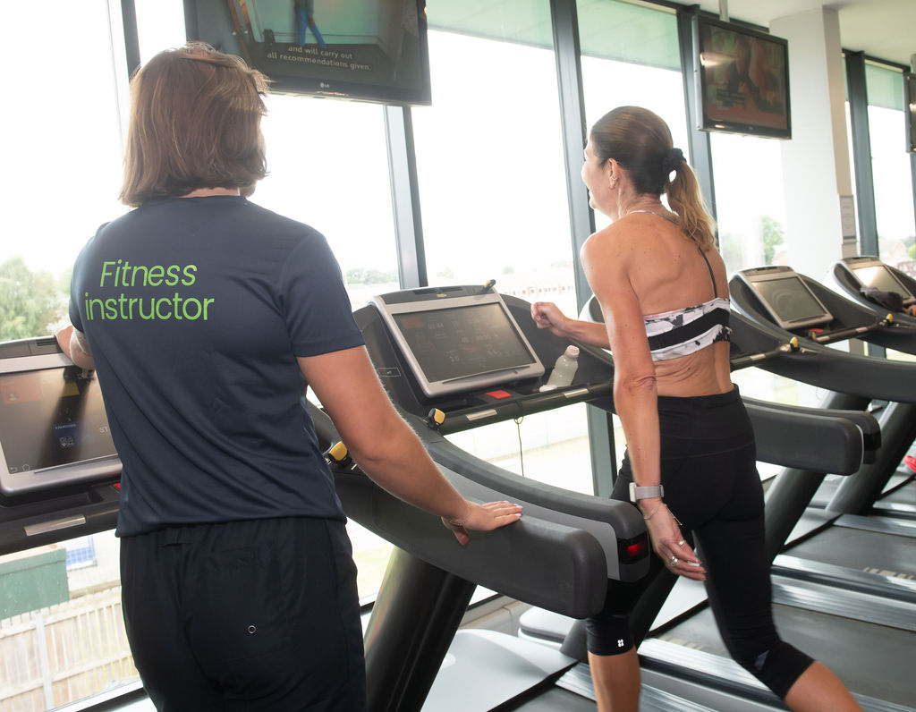 One of our fitness instructors showing a customer how the treadmill works