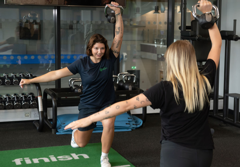 Two people taking part in a kettlebell exercise class