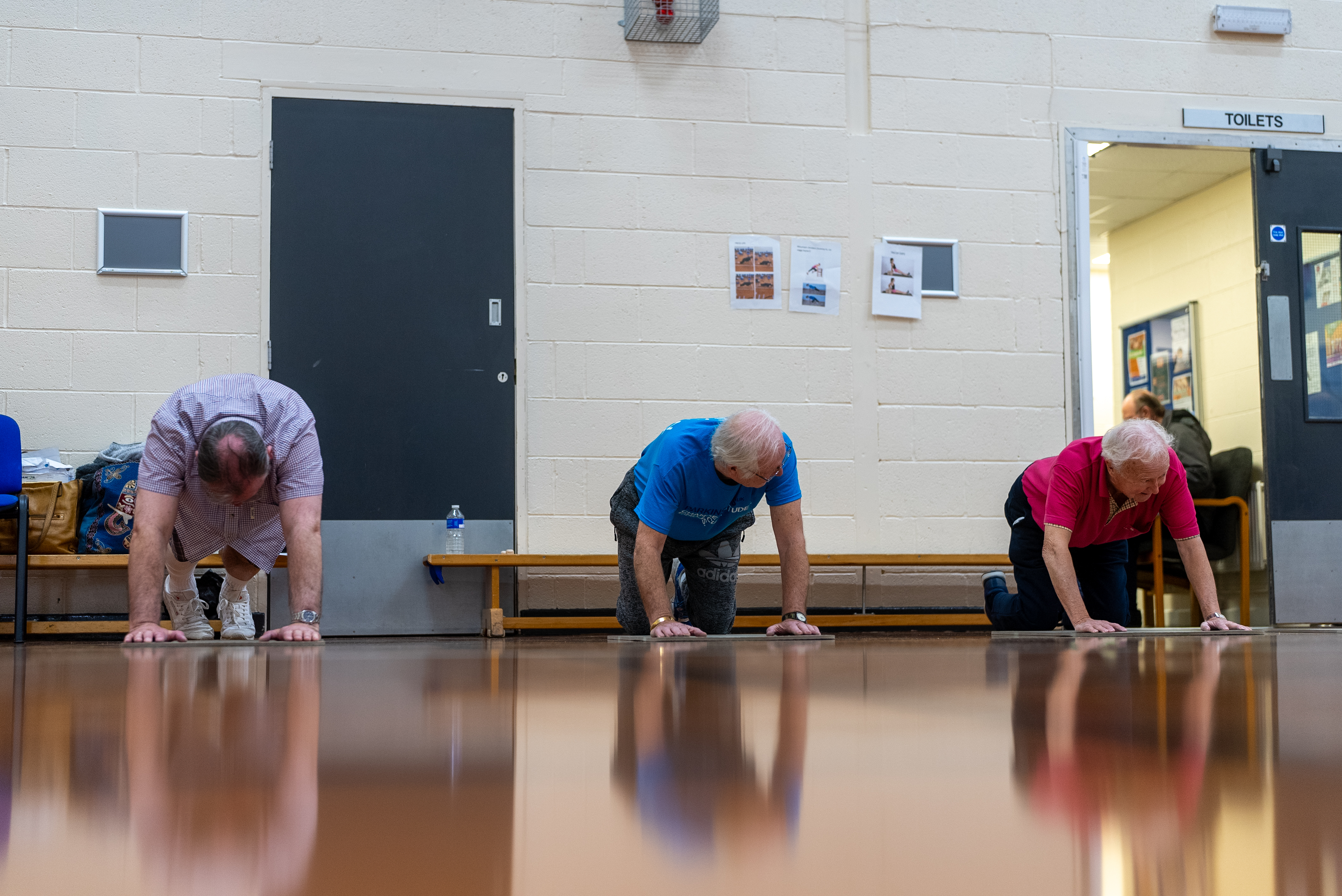 A group of men balancing on their hands and knees as part of a lifestyle class at Harrogate Leisure and Wellbeing Hub