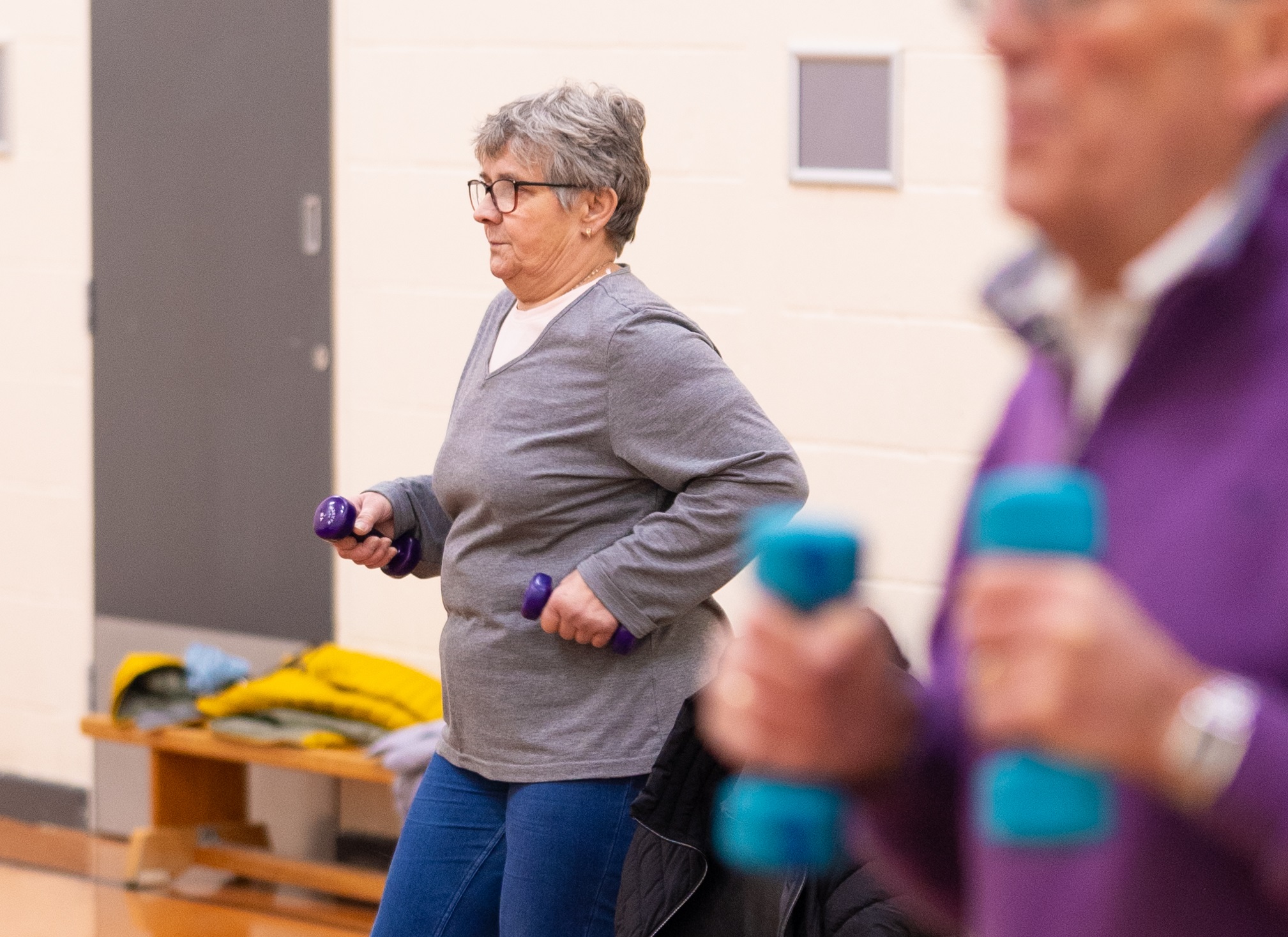 A man and woman holding dumbbells as part of an exercise class at Jennyfield Styan Community Wellbeing Hub
