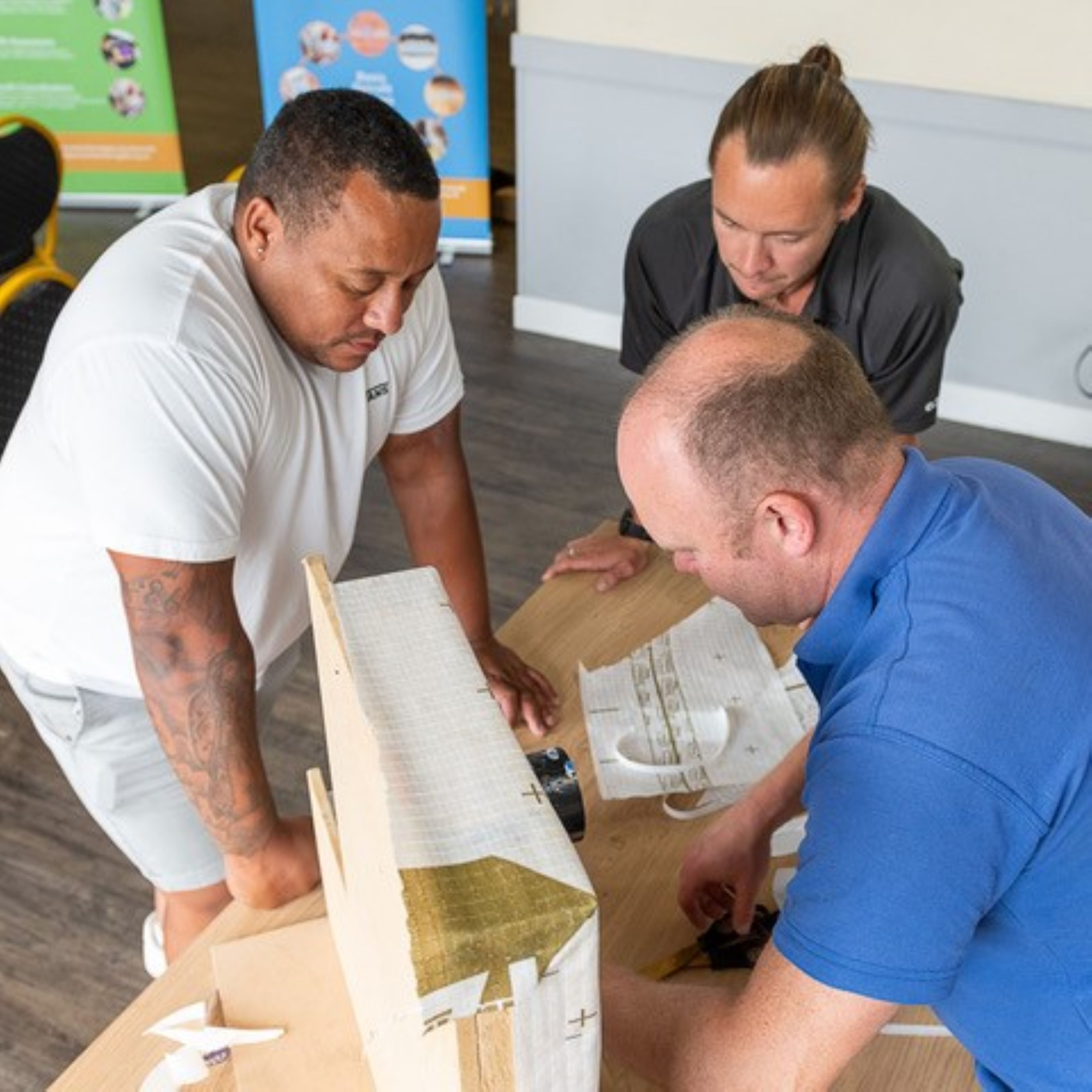 Three builders builders at a free class to train in energy efficiency techniques.