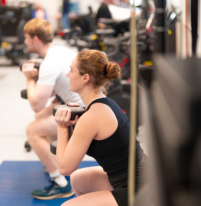 Two people doing squats while holding weights among the gym equipment at the Ripon Leisure and Wellbeing Hub - The Jack Laugher centre