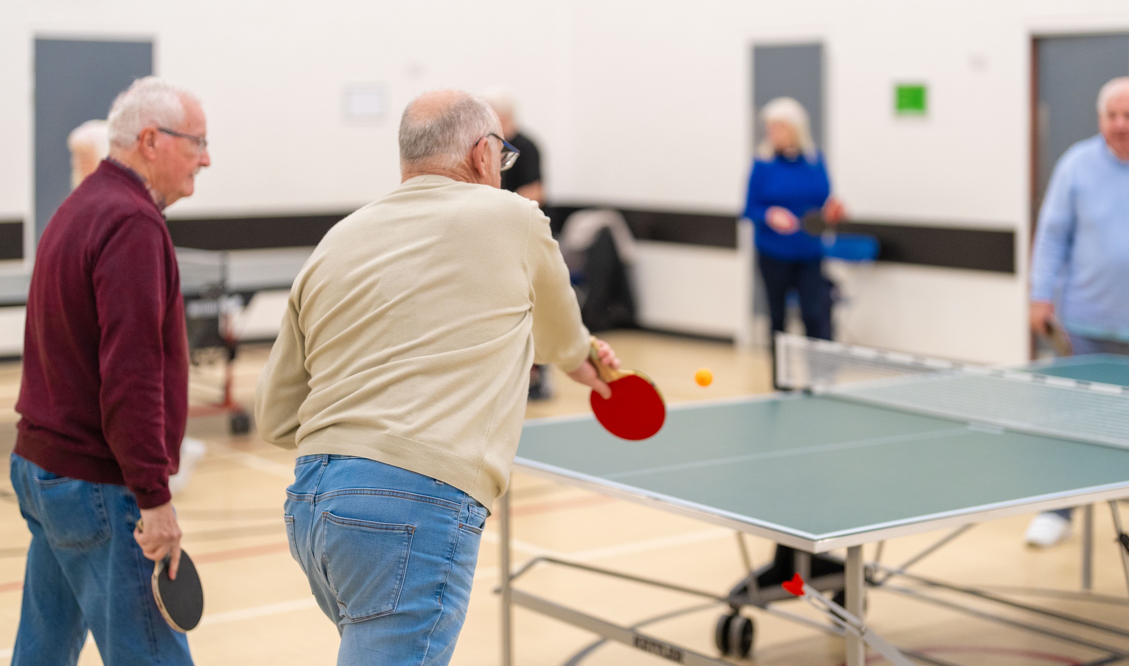 A group of men playing table tennis
