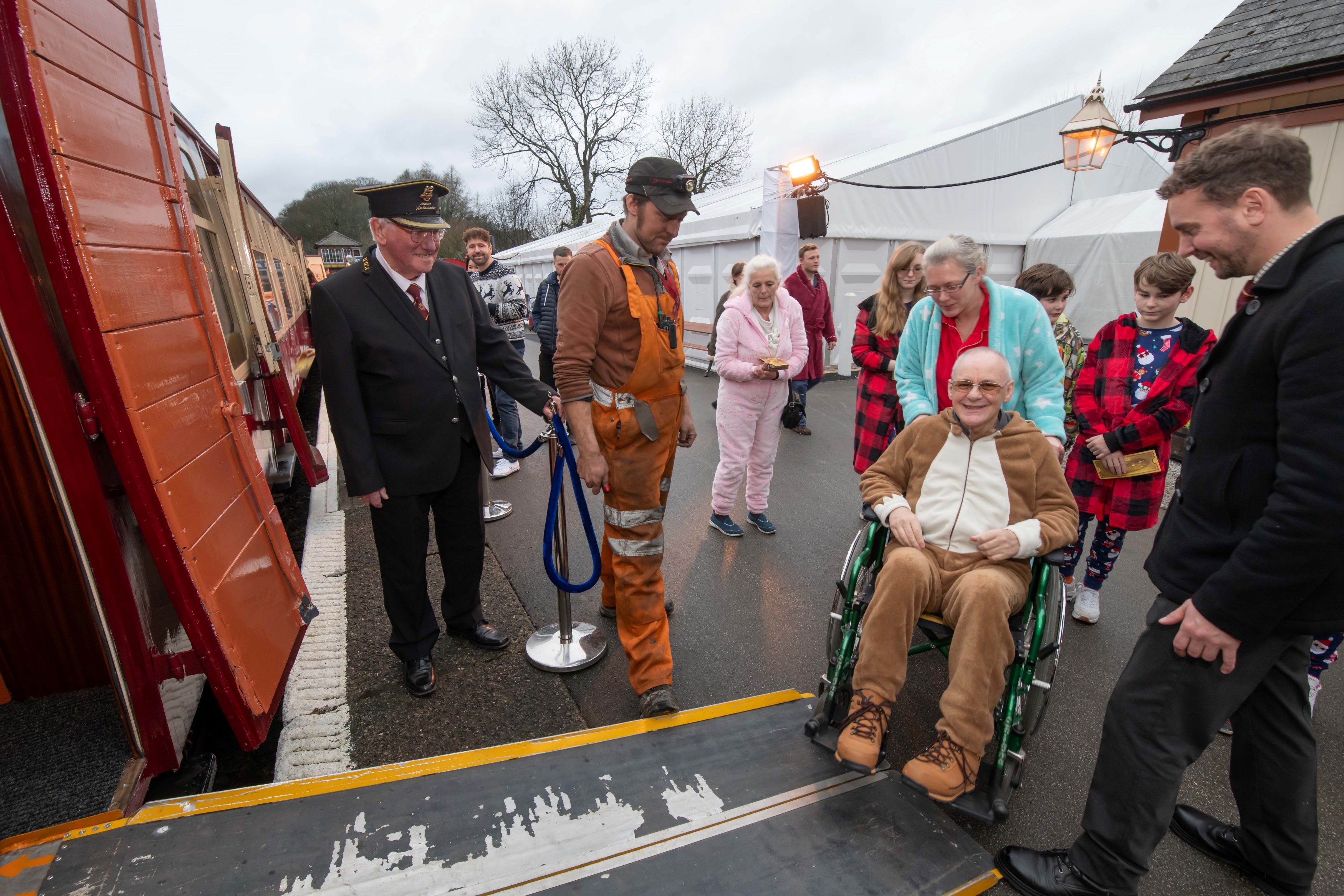 A person in a wheelchair being pushed onto a train