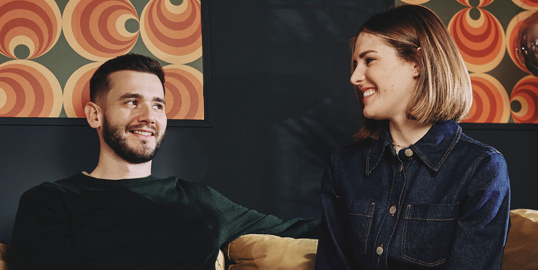Two employees of the Little Big Creative Agency sat on a sofa.