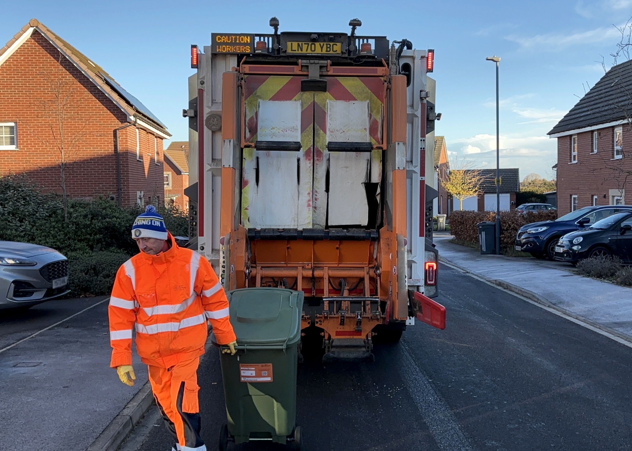 A binman collecting a green bin