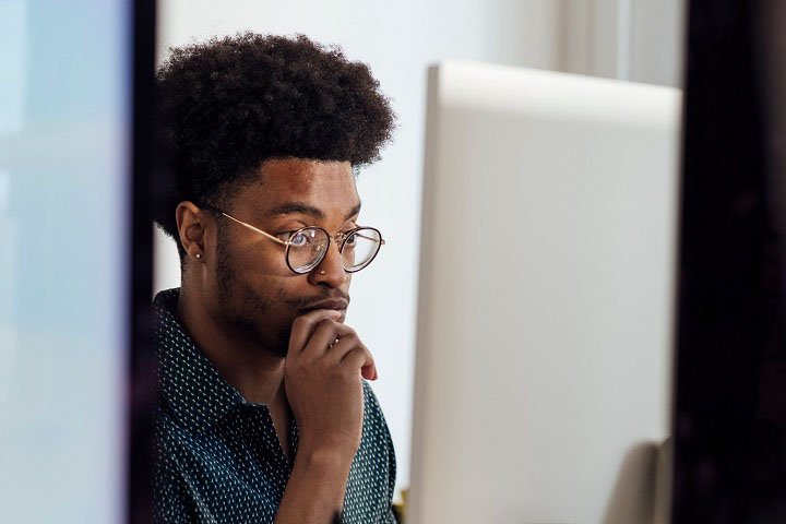 Man sat in front of a computer monitor