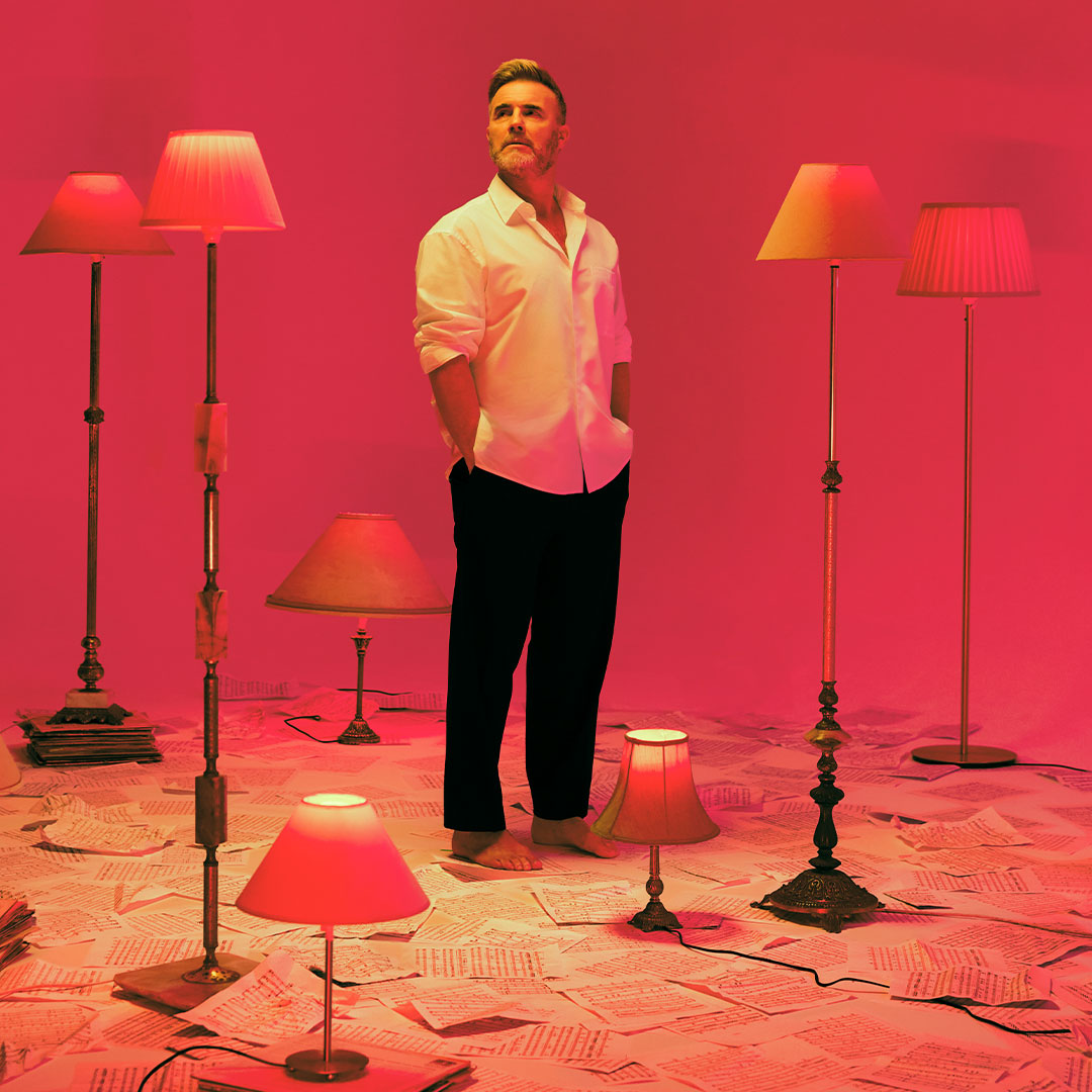 Image of Gary Barlow standing in the middle of lamps