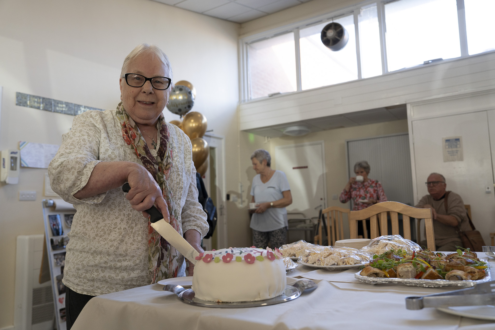 Dot cutting her retirement cake